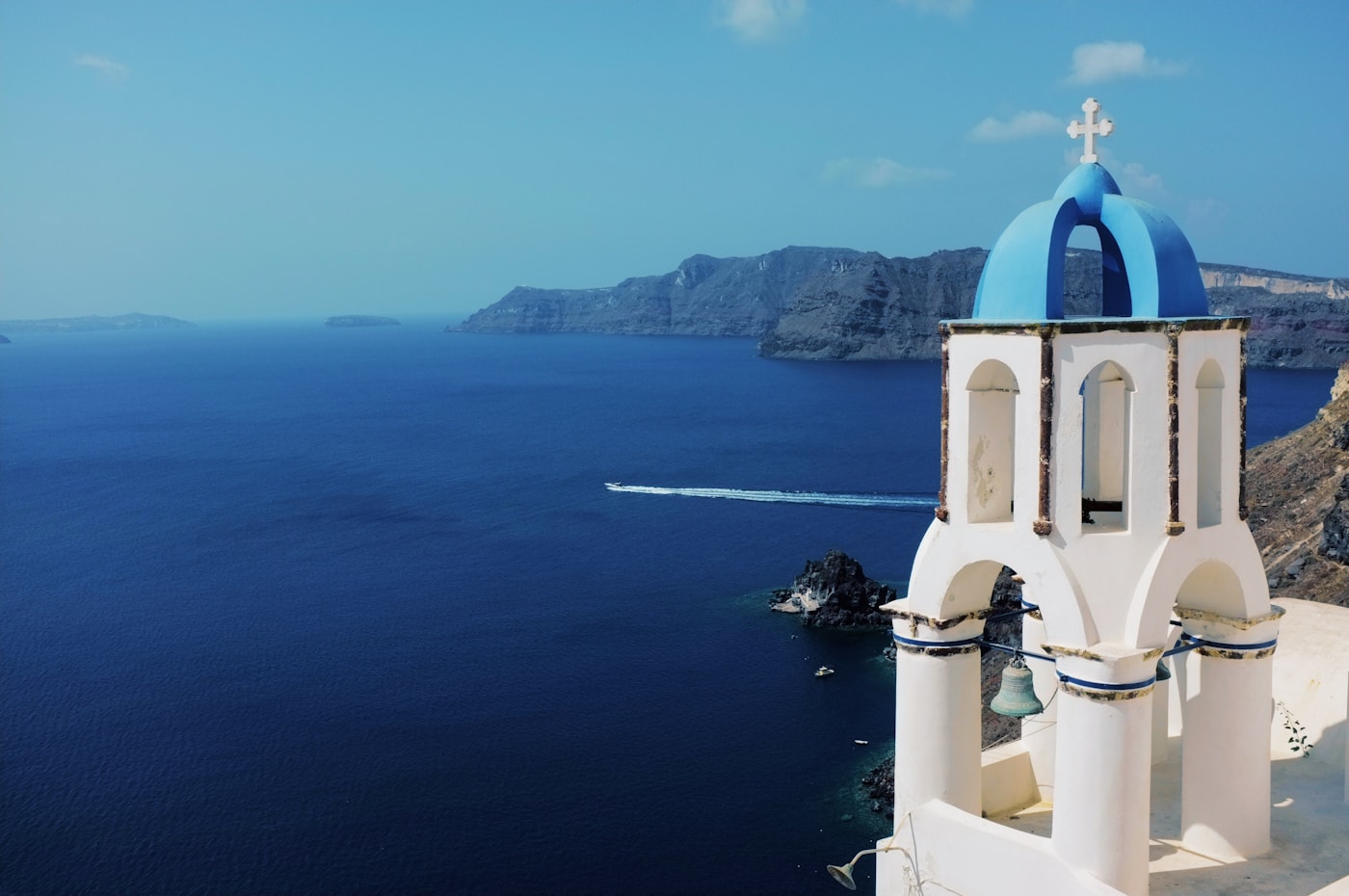 A white church tower overlooking blue water