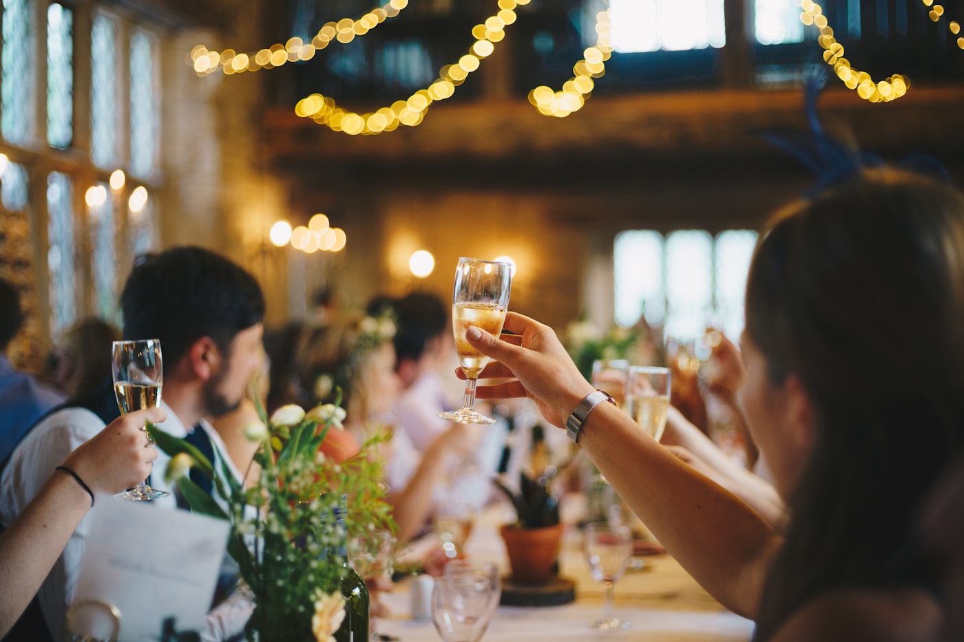 Guests raising glasses at a warmly lit dinner