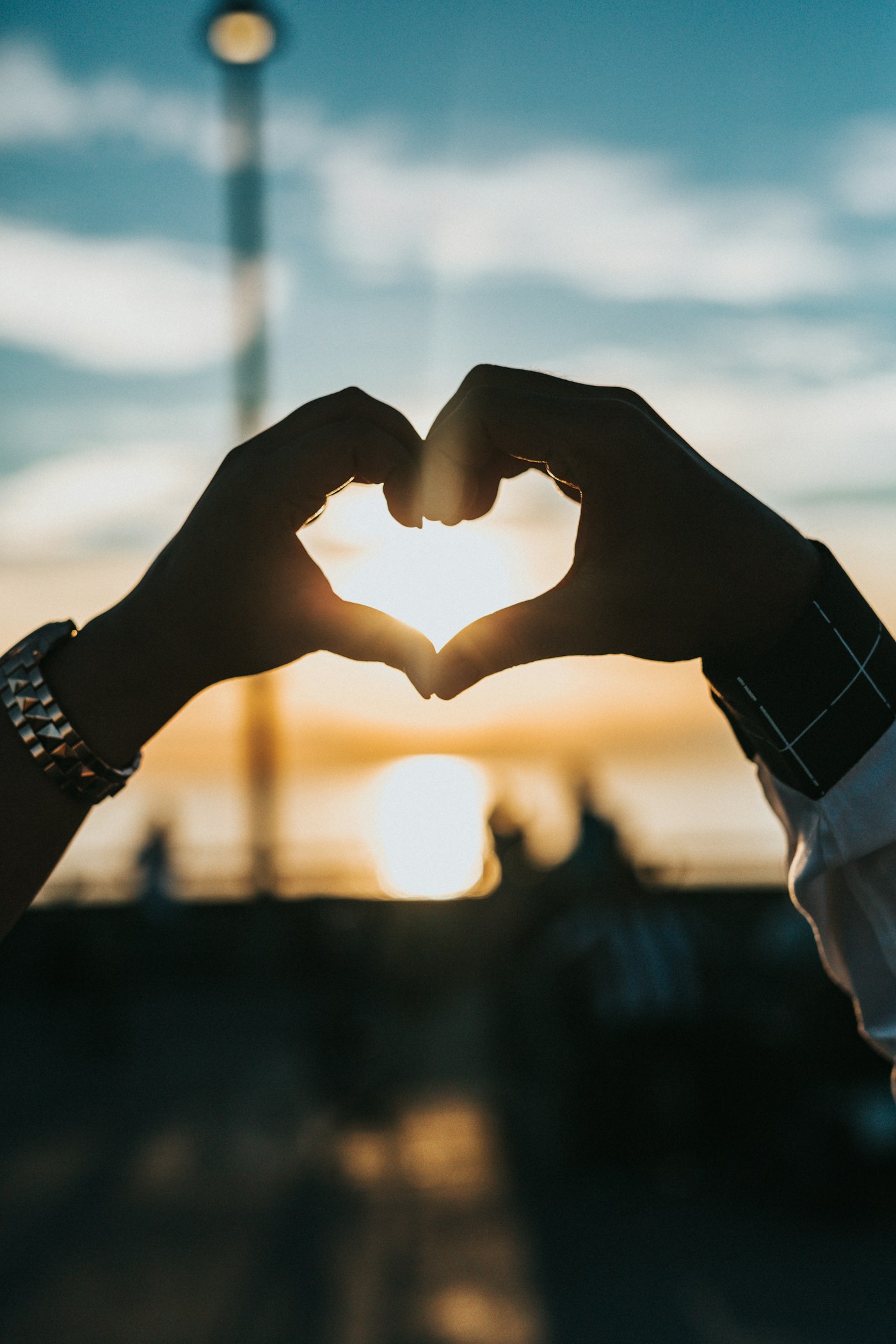 Hands forming a heart shape in evening light