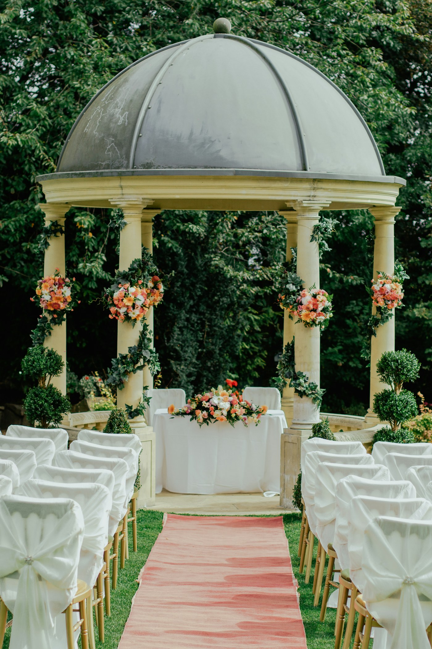 A flower-covered wedding pavilion among trees