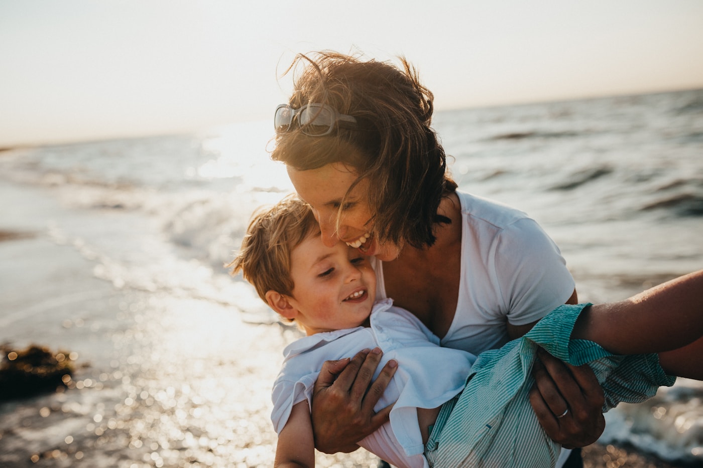 A parent holding a child by the sea